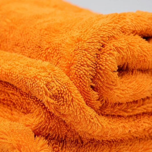 Extreme close-up photography of a premium microfiber drying towel, ultra dense microfiber fibers (1400 GSM) clearly visible, soft fluffy texture, realistic fabric detail, shallow depth of field, studio lighting, luxury automotive detailing product, hyper realistic, ultra sharp, commercial photography